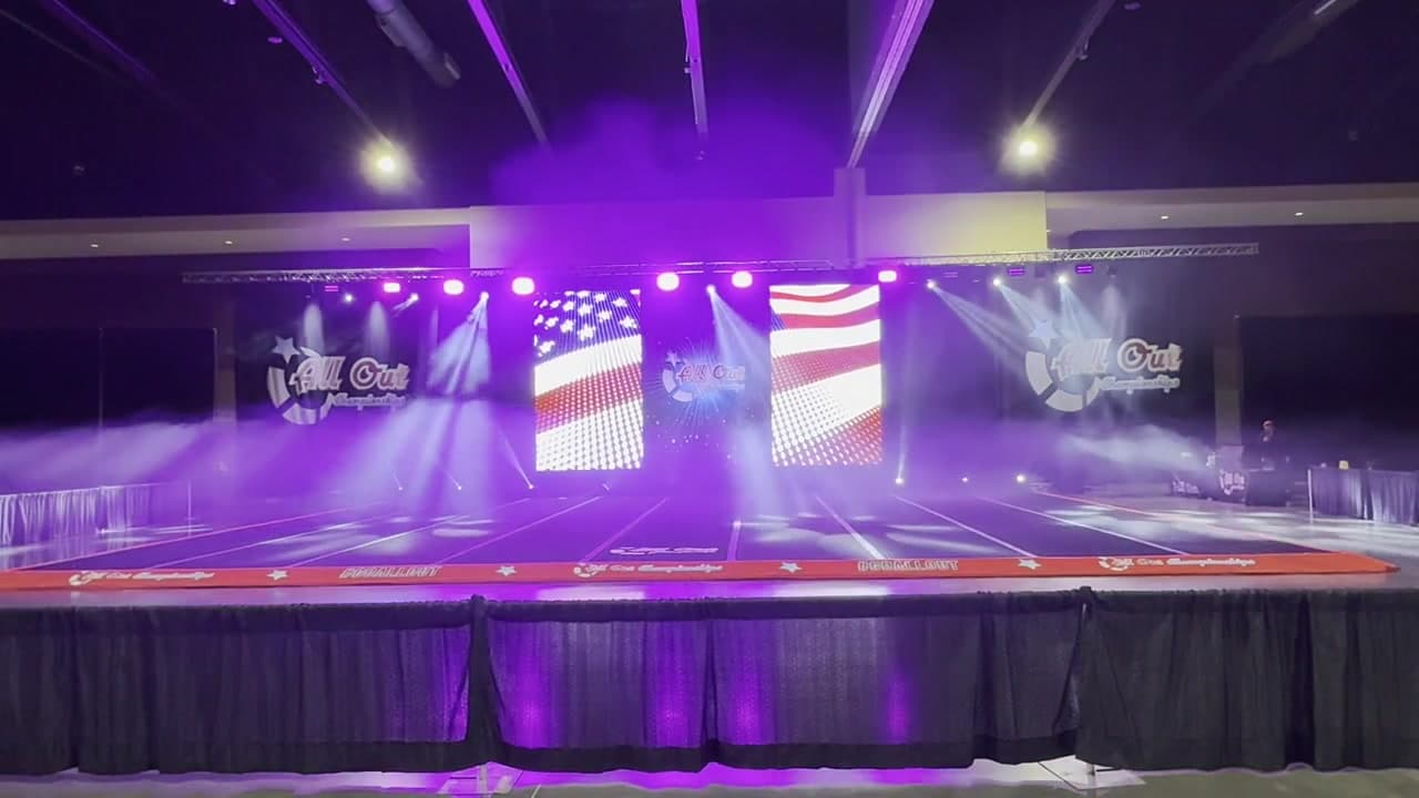 Cheer event stage prepared with LED screens and purple lighting