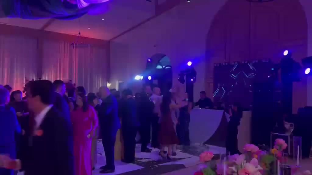 Guests gathering on a blue-lit dance floor at a reception