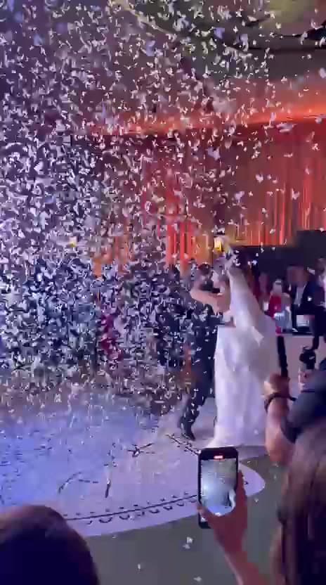 Newlyweds surrounded by confetti during a reception celebration